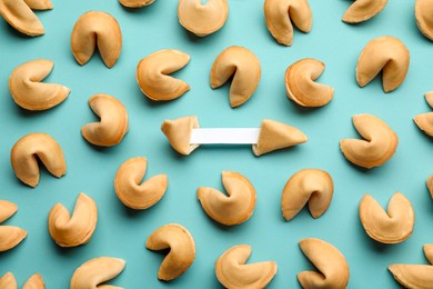 Tasty fortune cookies with predictions on light blue background, flat lay. Space for text