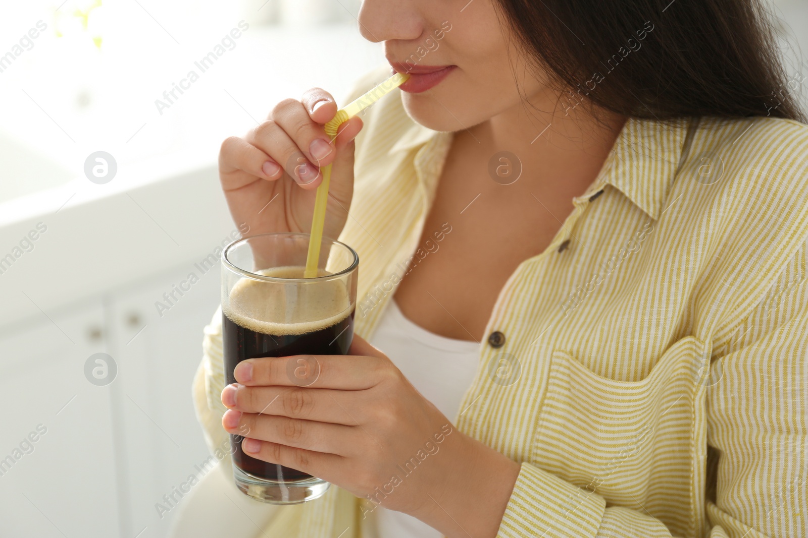 Photo of Young woman with cold kvass indoors, closeup. Traditional Russian summer drink