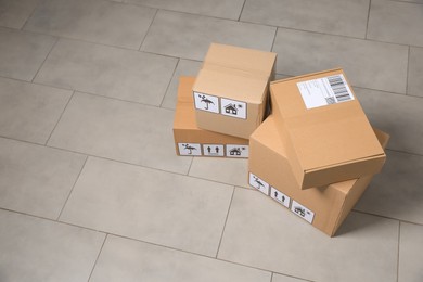 Photo of Many closed cardboard boxes with packaging symbols on floor, space for text. Delivery service