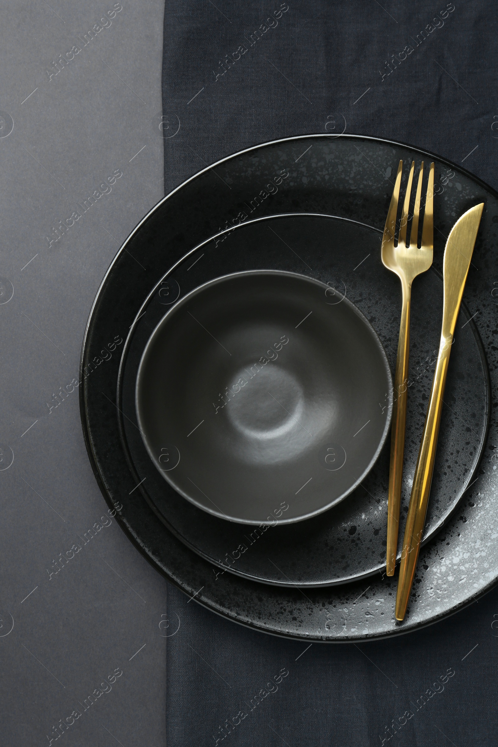 Photo of Stylish ceramic plates, bowl and napkin on grey background, top view