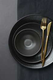 Photo of Stylish ceramic plates, bowl and napkin on grey background, top view