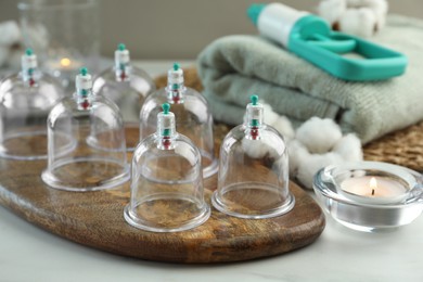 Photo of Many plastic cups on white table. Cupping therapy