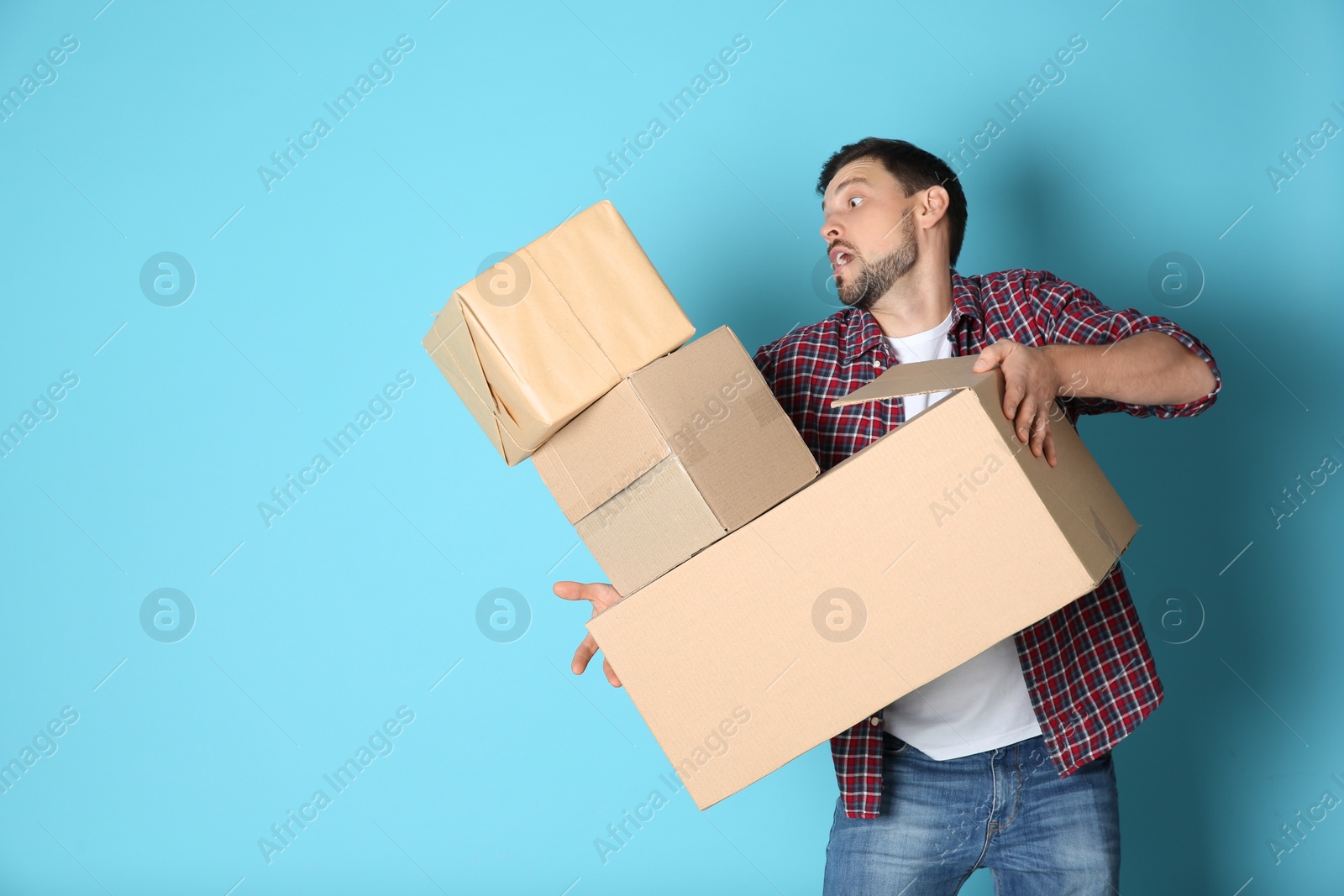 Photo of Man dropping moving boxes on color background. Space for text