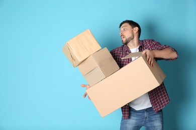 Man dropping moving boxes on color background. Space for text