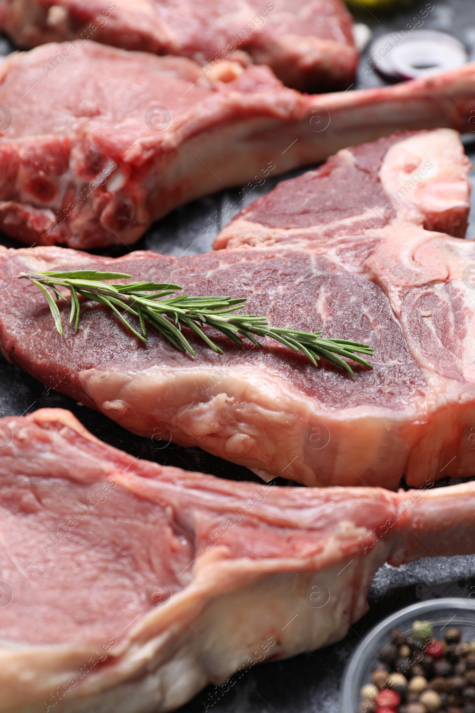 Photo of Fresh raw beef cuts and different spices on table, closeup