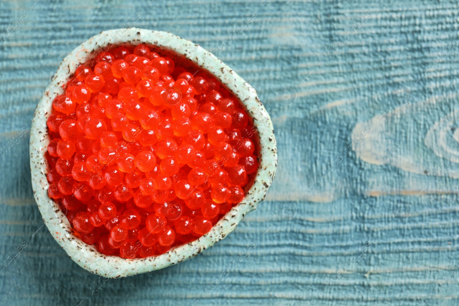 Photo of Ceramic bowl with delicious red caviar on table