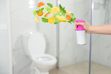 Image of Woman spraying air freshener in bathroom, closeup. Citrusy and minty aroma