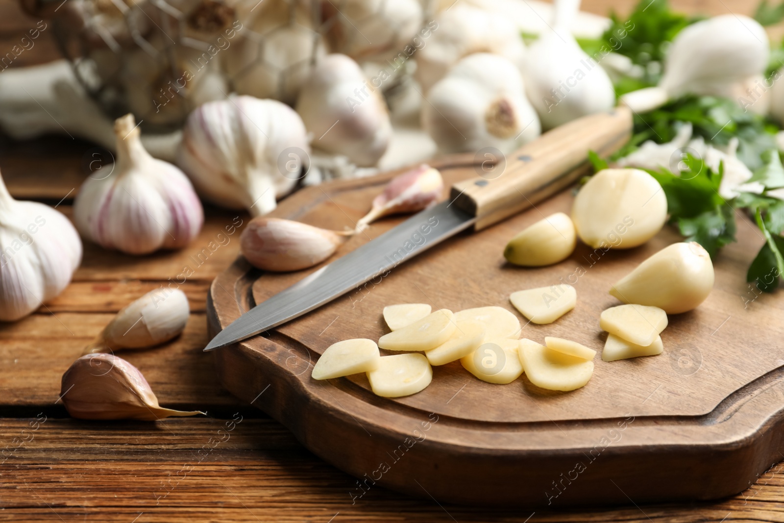 Photo of Fresh whole and cut garlic on wooden table. Organic product
