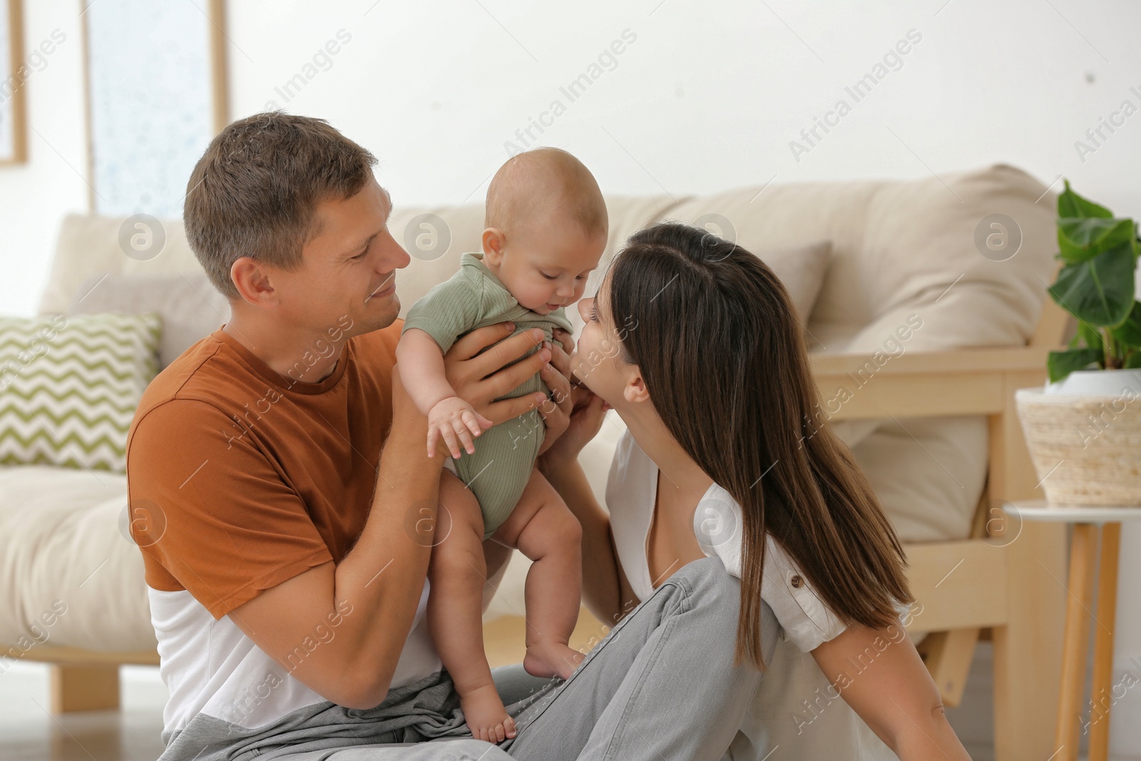 Photo of Portrait of happy family with their cute baby at home