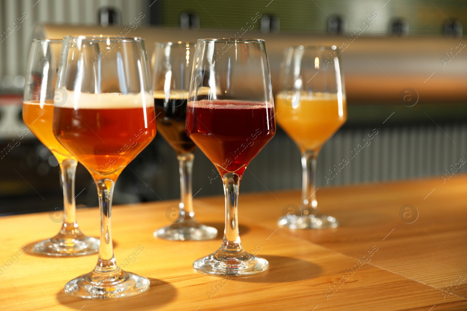 Photo of Different sorts of beer on wooden bar counter