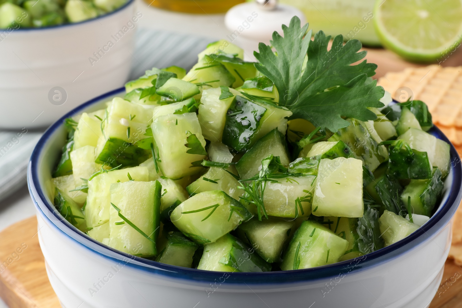 Photo of Bowl of delicious cucumber salad on table, closeup