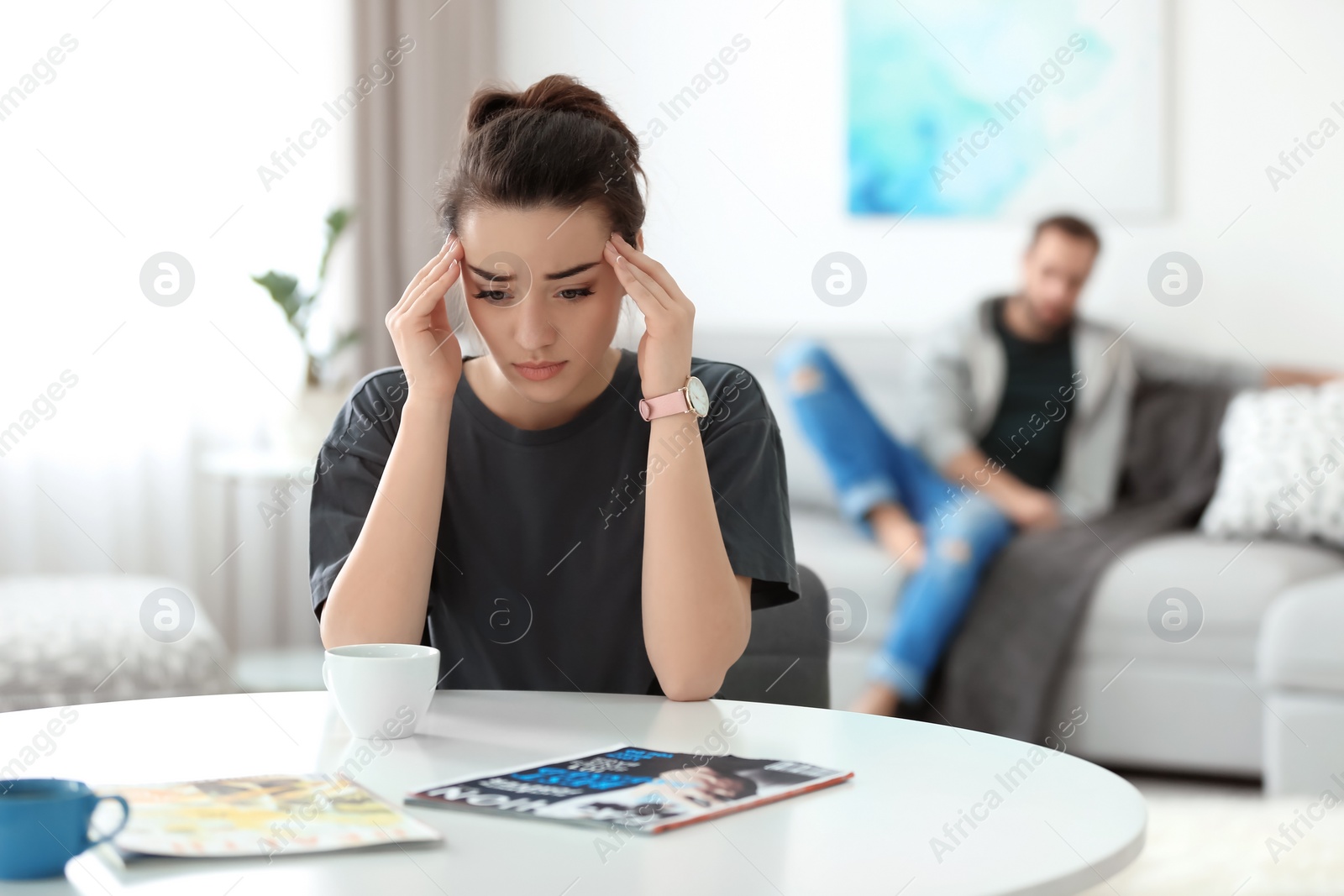 Photo of Young couple ignoring each other after having argument in living room