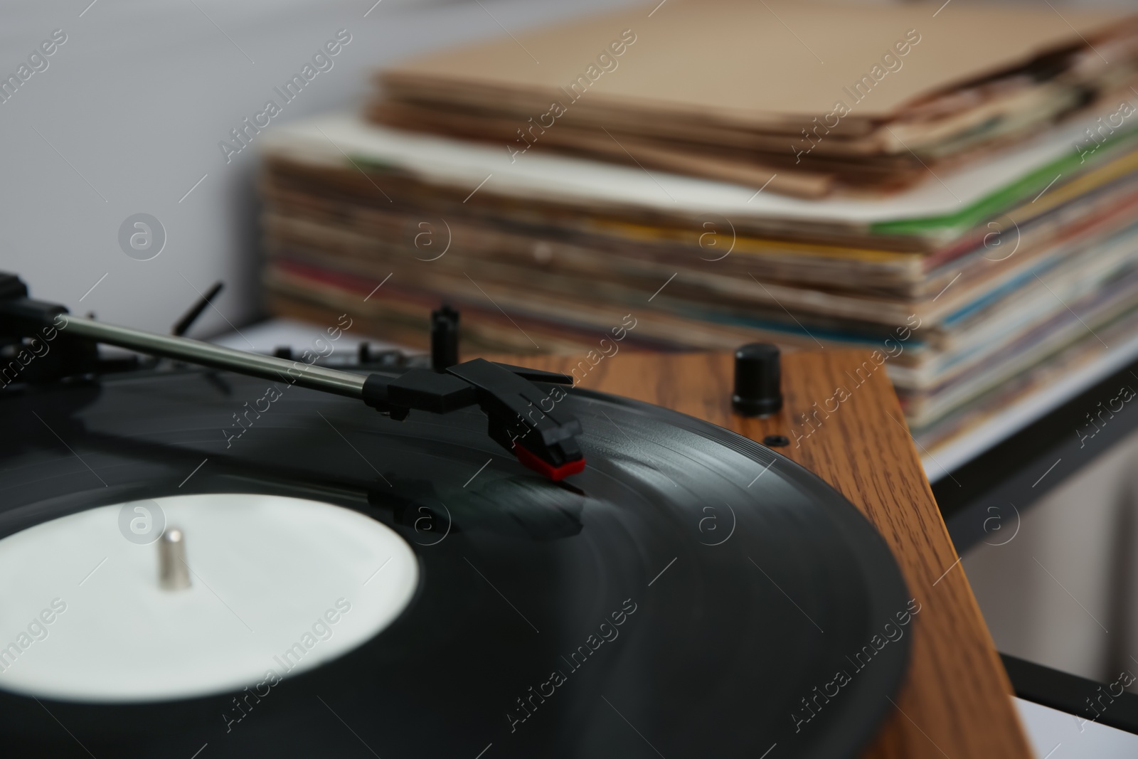 Photo of Stylish turntable with vinyl record on table, closeup