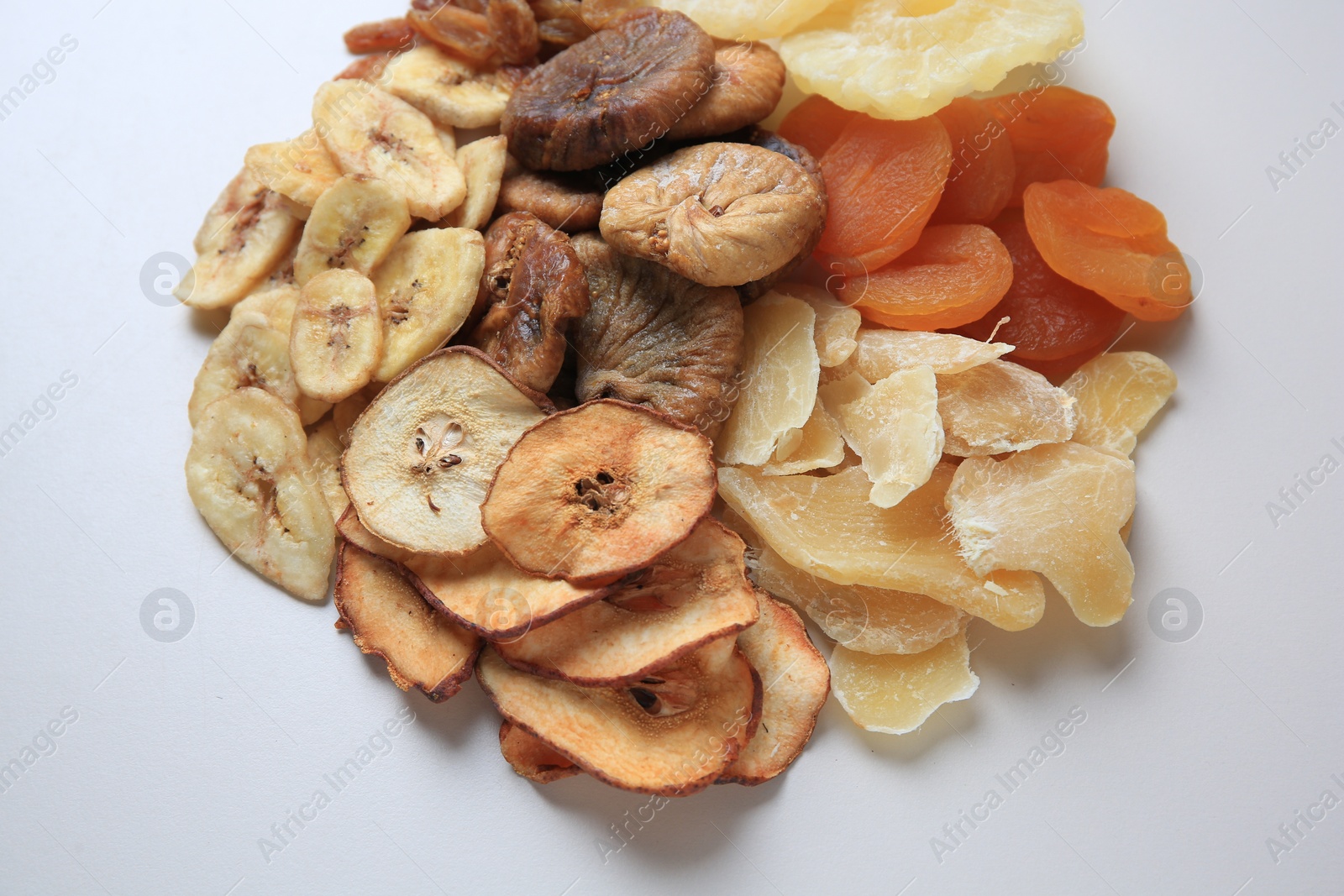 Photo of Pile of different dried fruits on white background, closeup