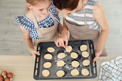 Photo of Mother and her daughter with cookie dough in kitchen