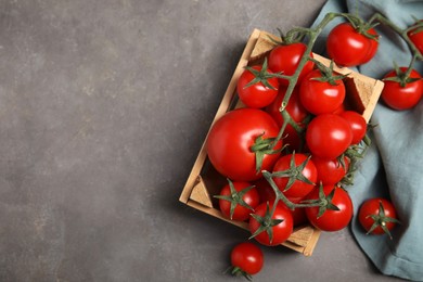 Photo of Many ripe red tomatoes in wooden crate on grey table, flat lay. Space for text