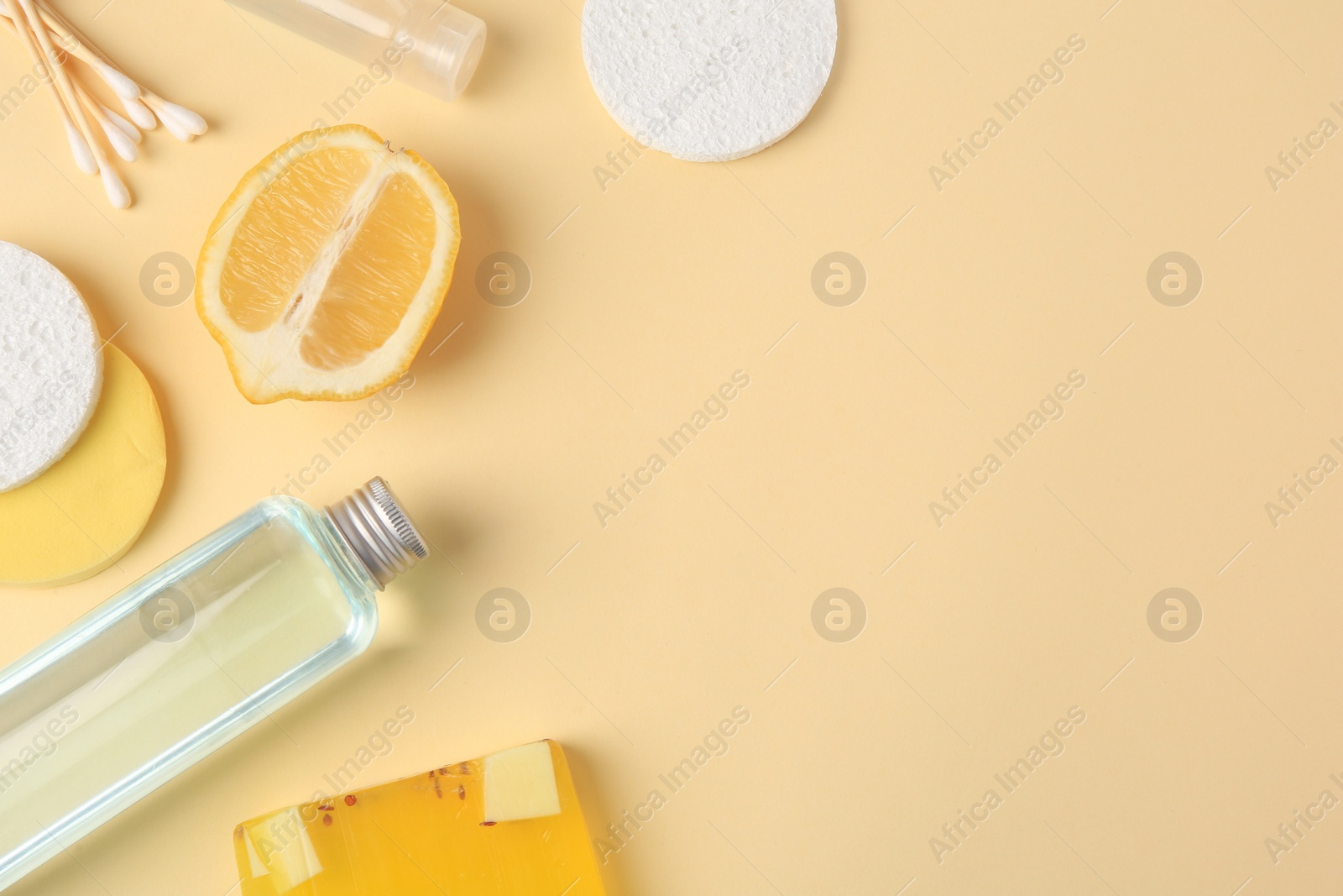 Photo of Lemon face cleanser. Fresh citrus fruits and personal care products on beige background, flat lay with space for text