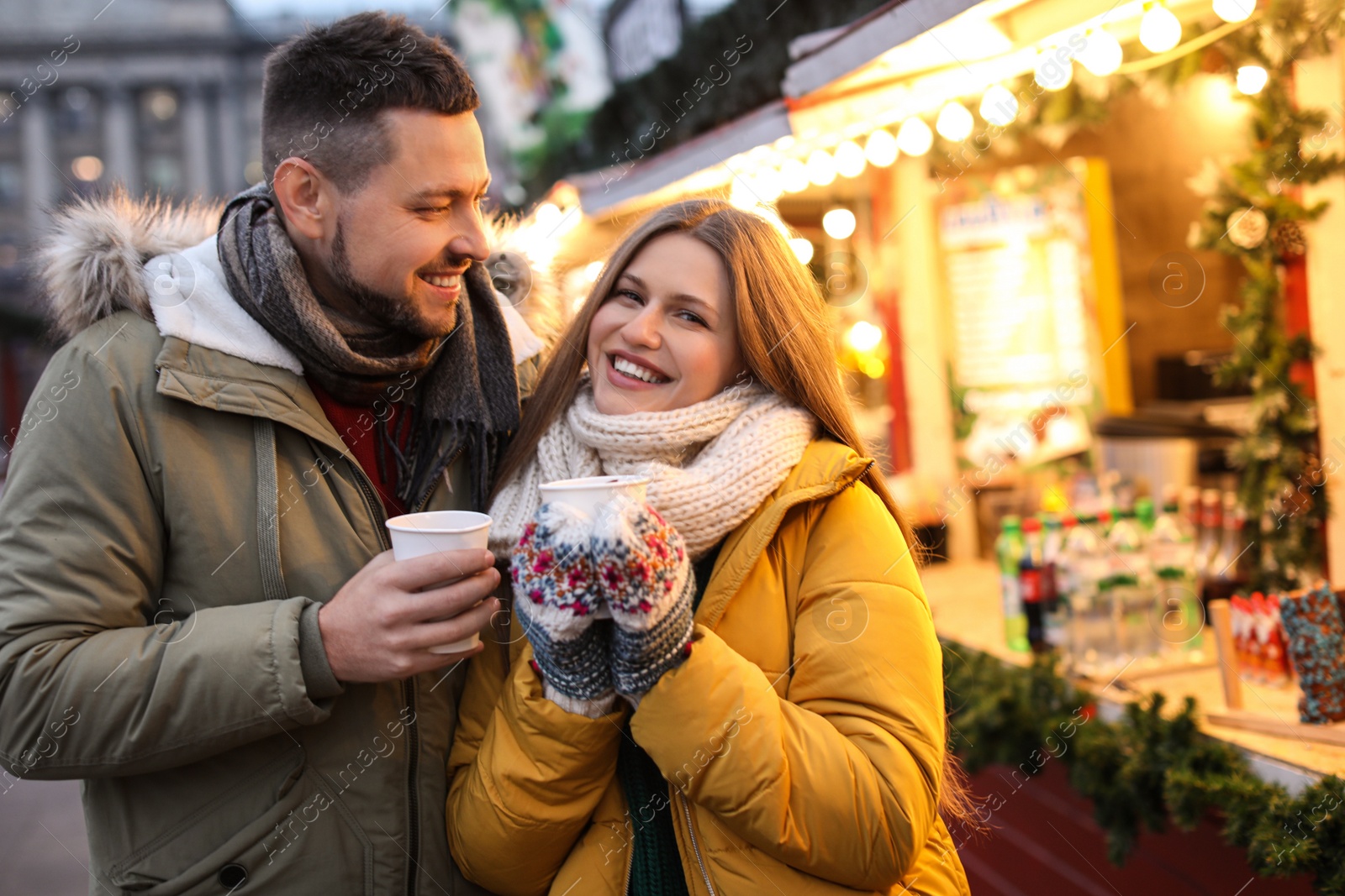 Photo of Happy couple with mulled wine at winter fair