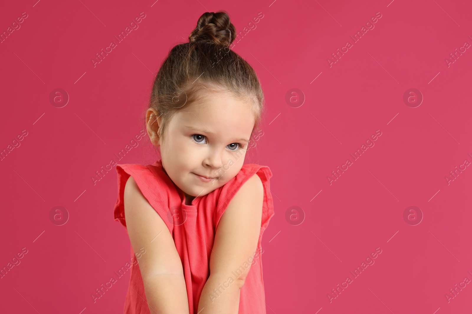 Photo of Portrait of cute little girl on pink background