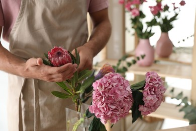 Photo of Florist with beautiful flowers in workshop, closeup