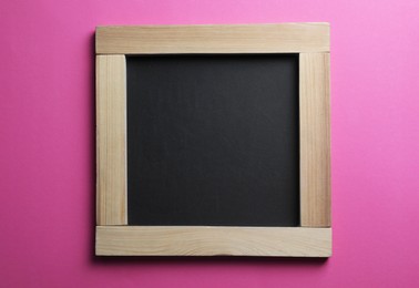 Blank chalkboard on pink background, top view. Space for text