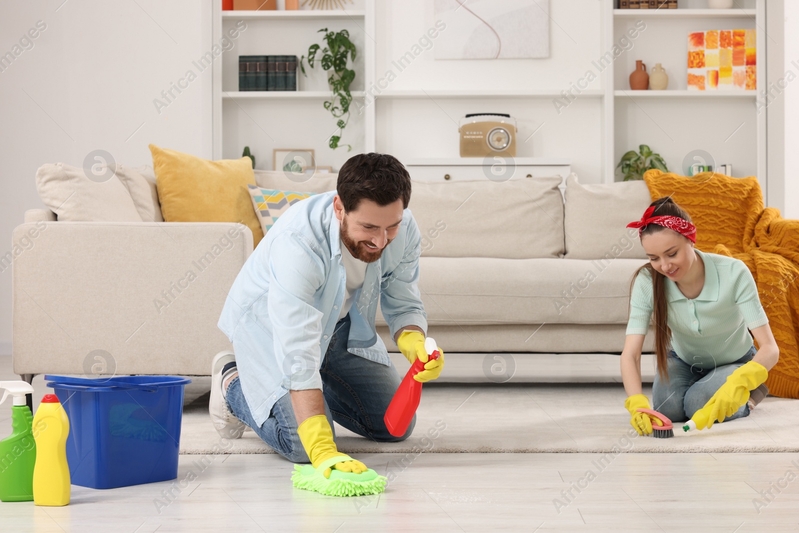 Photo of Spring cleaning. Couple tidying up living room together