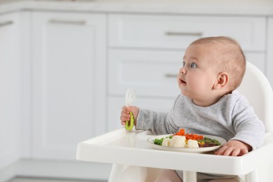 Cute little baby eating healthy food at home. Space for text