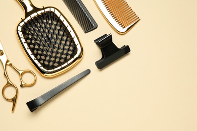 Photo of Hairdressing tools on beige background, flat lay. Space for text