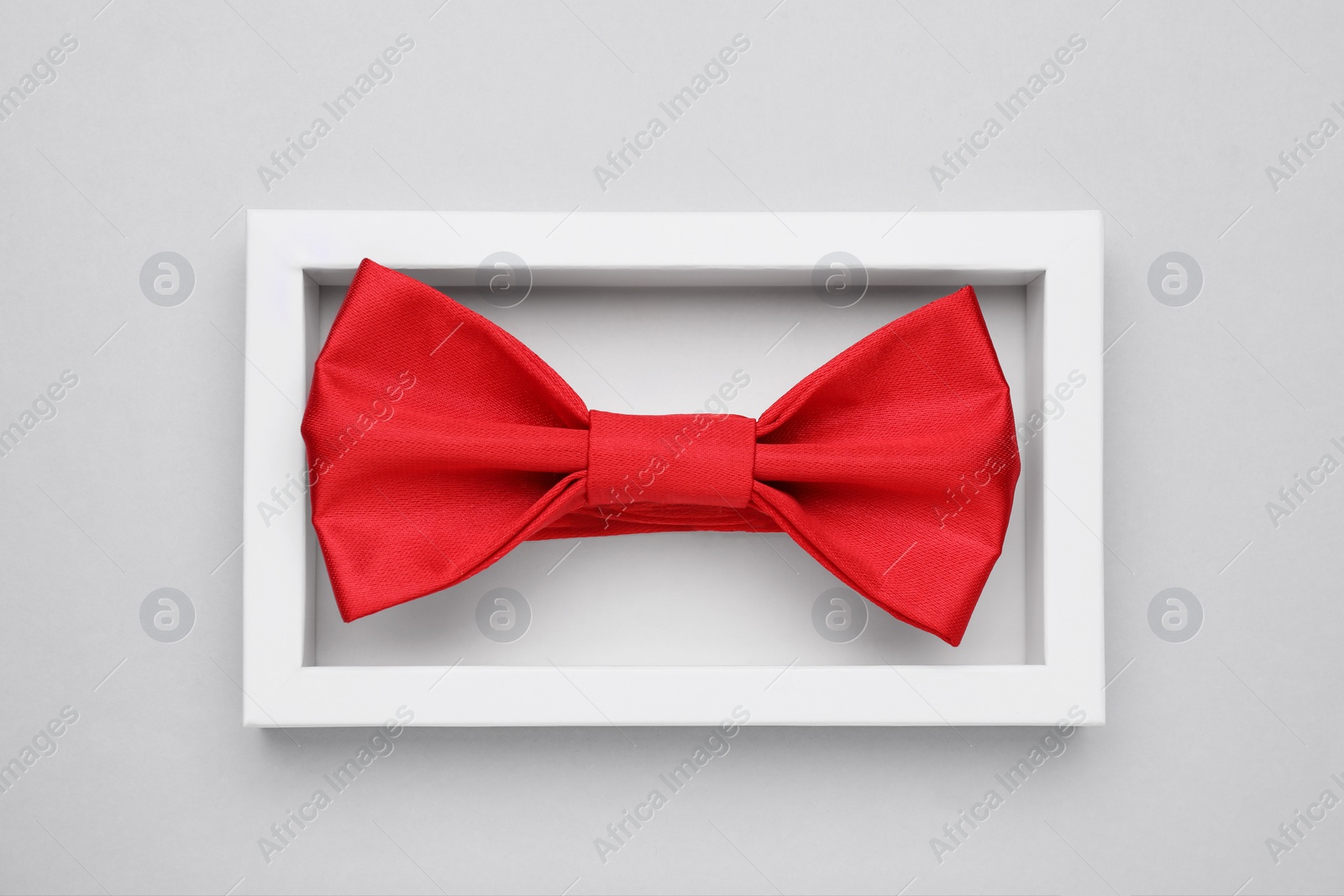 Photo of Stylish red bow tie in box on white background, top view