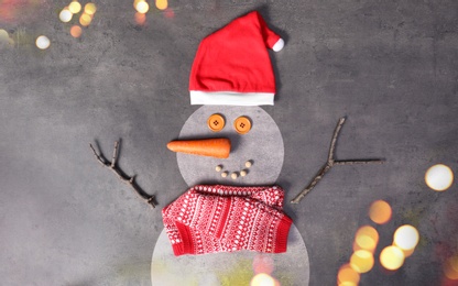 Image of Snowman with Santa hat and scarf on grey background, flat lay. Bokeh effect 