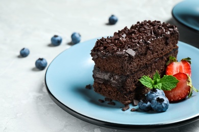 Delicious fresh chocolate cake with berries on table, closeup