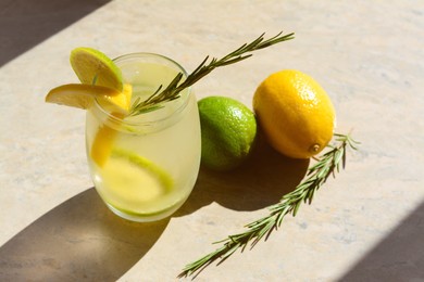 Photo of Tasty refreshing lemonade and ingredients on light table. Summer drink