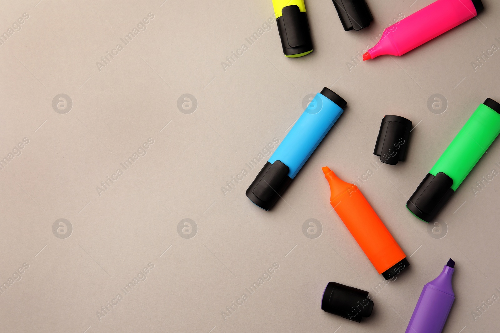 Photo of Bright color markers on light grey background, flat lay. Space for text