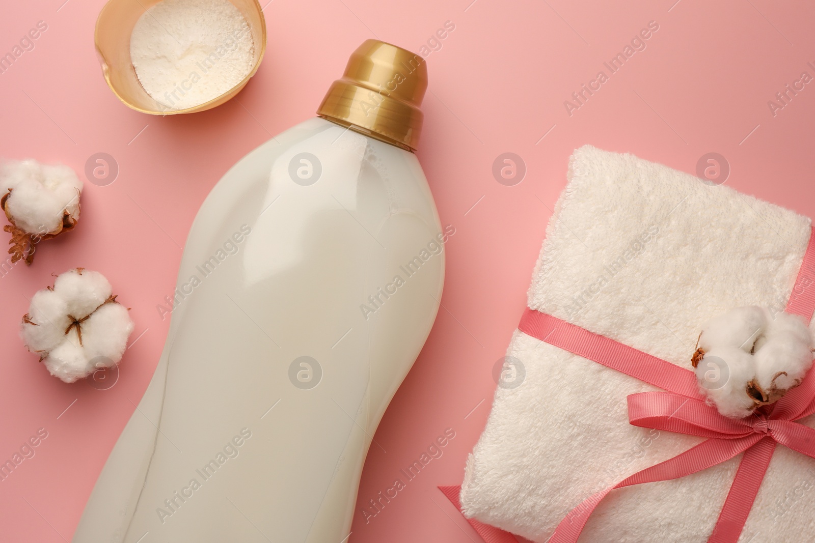 Flat lay composition with bottle of fabric softener on pink background Photo of Flat lay composition with bottle of fabric softener on pink background