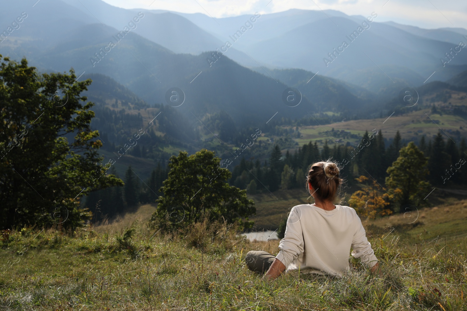 Photo of Woman enjoying beautiful mountain landscape, back view. Space for text