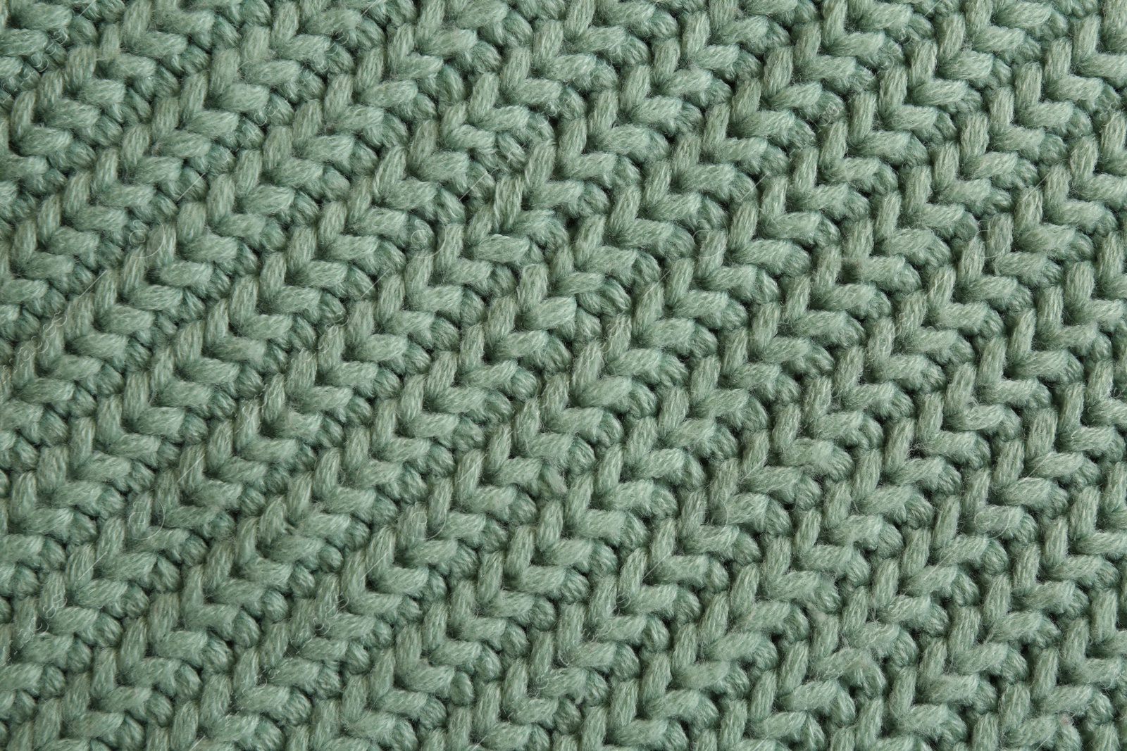 Photo of Beautiful pale green knitted fabric as background, top view