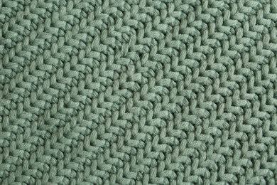 Beautiful pale green knitted fabric as background, top view