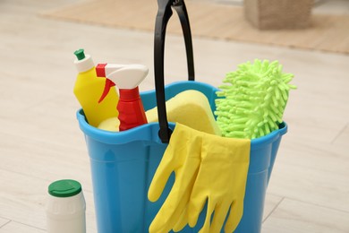 Photo of Different cleaning products and bucket on floor indoors