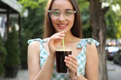 Photo of Young woman with cold kvass outdoors. Traditional Russian summer drink