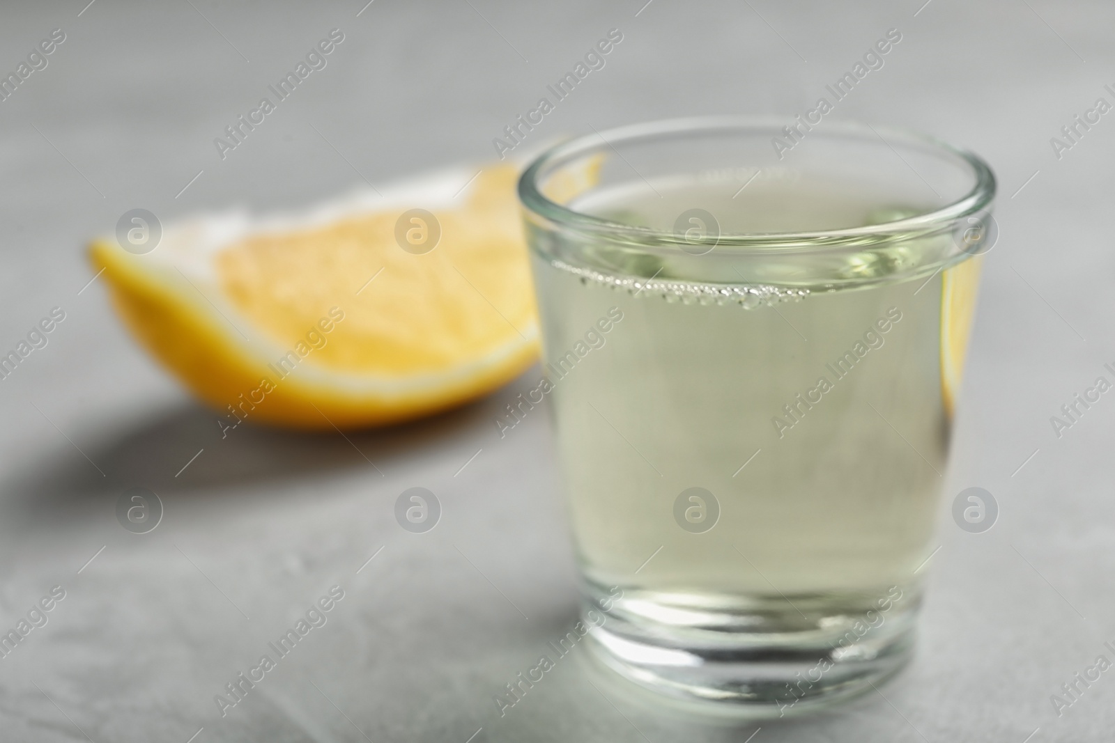 Photo of Glass with mouthwash and lemon on light background. Teeth care