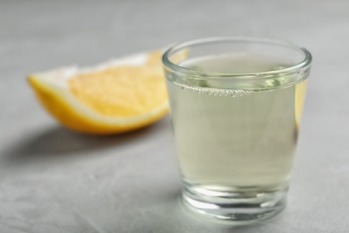 Glass with mouthwash and lemon on light background. Teeth care