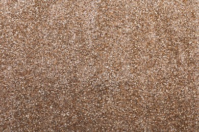 Photo of Shiny light brown glitter as background, closeup