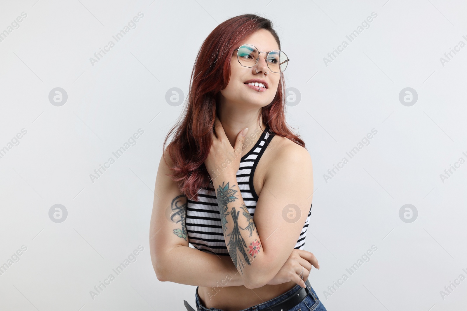 Photo of Portrait of beautiful tattooed woman on gray background