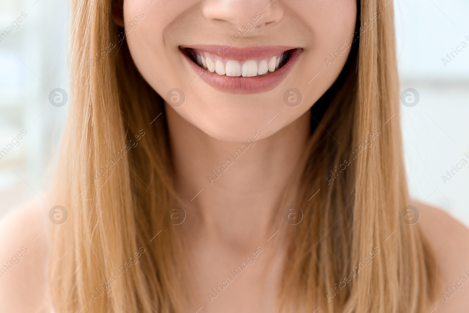 Photo of Young woman with beautiful smile indoors. Teeth whitening