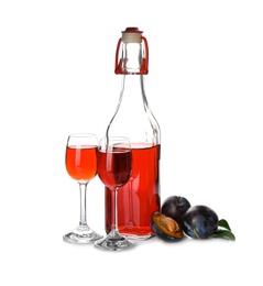 Delicious plum liquor and ripe fruits on white background. Homemade strong alcoholic beverage