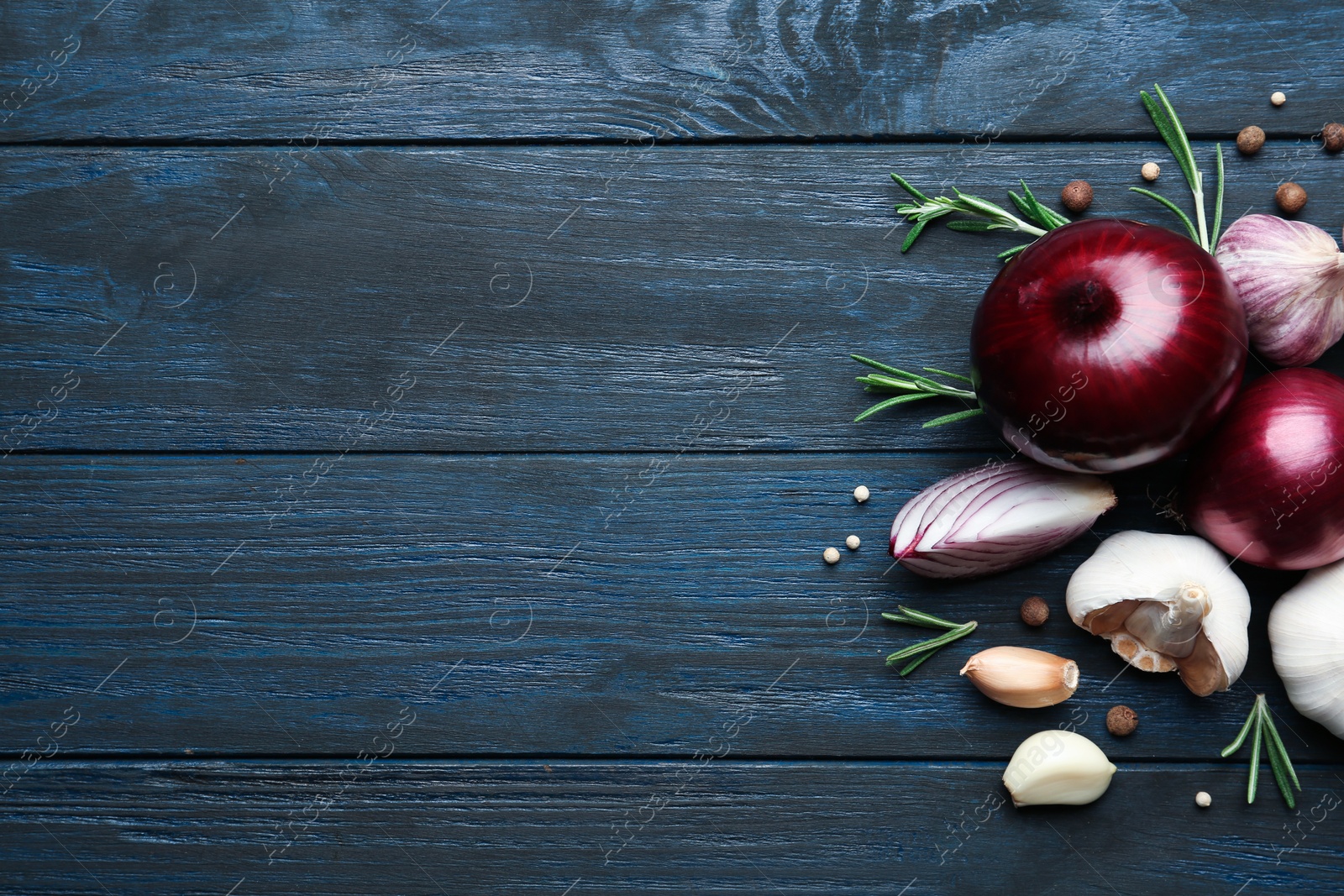 Photo of Flat lay composition with garlic, onions and space for text on wooden background