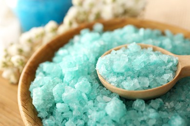 Photo of Spoon and bowl of aromatic sea salt on table, closeup