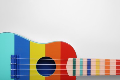 Photo of Colorful ukulele on white background, top view with space for text. String musical instrument