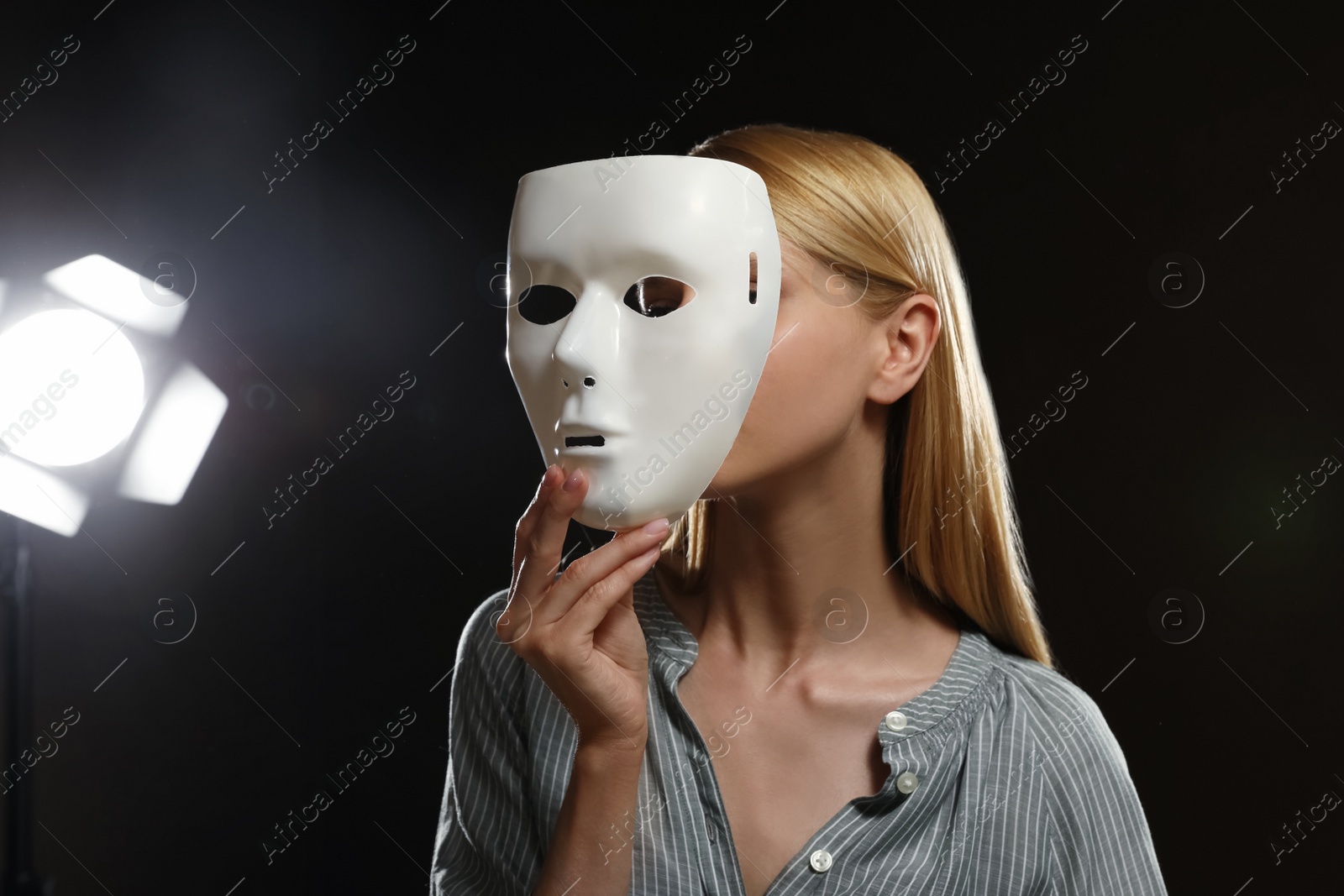Photo of Professional actress with mask on stage in theatre