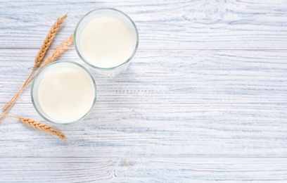 Photo of Glasses of milk on wooden table. Fresh dairy product